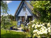 Veranda aus grauem Granit mit diversen blauen Pflanztpfen umrandet